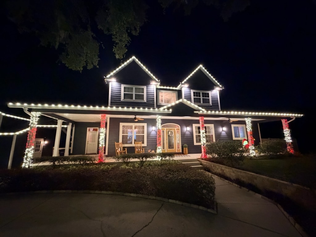 Two-story home with roofline and column Christmas lights